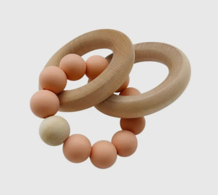 Soothe & stimulate your baby with this natural teething set! Silicone peach teether & beechwood rattle rings help develop motor skills & senses through grasping, textures. 100% safe for 3+ months.