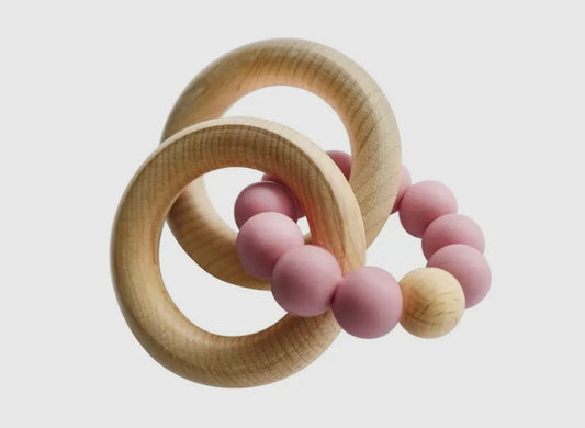 Soothe &amp; stimulate with Tiny Teethers' silicone rose teether &amp; beechwood rattle rings. 100% safe materials aid baby's development of motor skills &amp; senses through grasping/textures. Ideal for 3+ months.